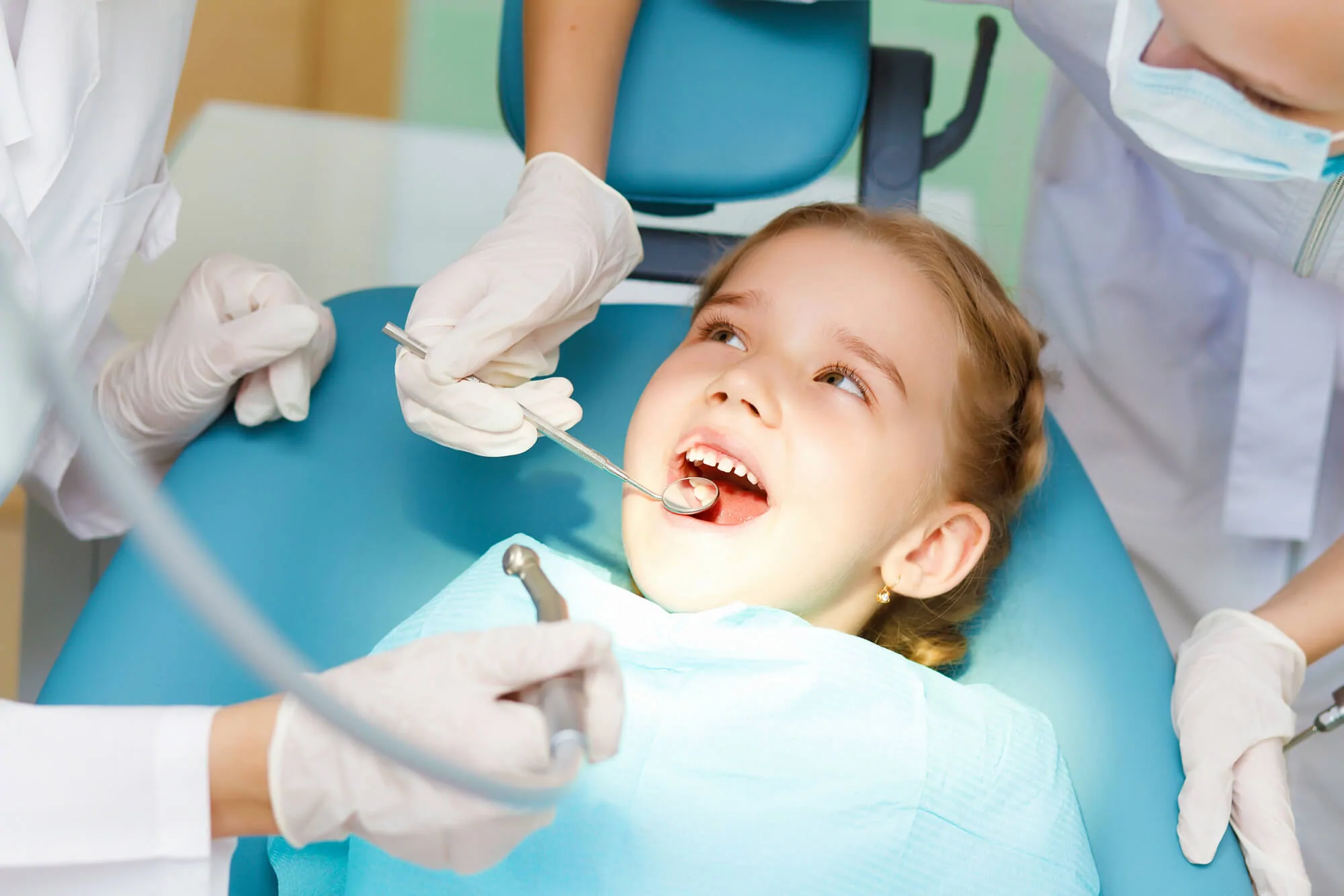 Lufkin Kids Dentistry Dental Hygienist Britany in a treatment room smiling sitting next to a happily smiling pediatric patient sitting in the dentist treatment chair
